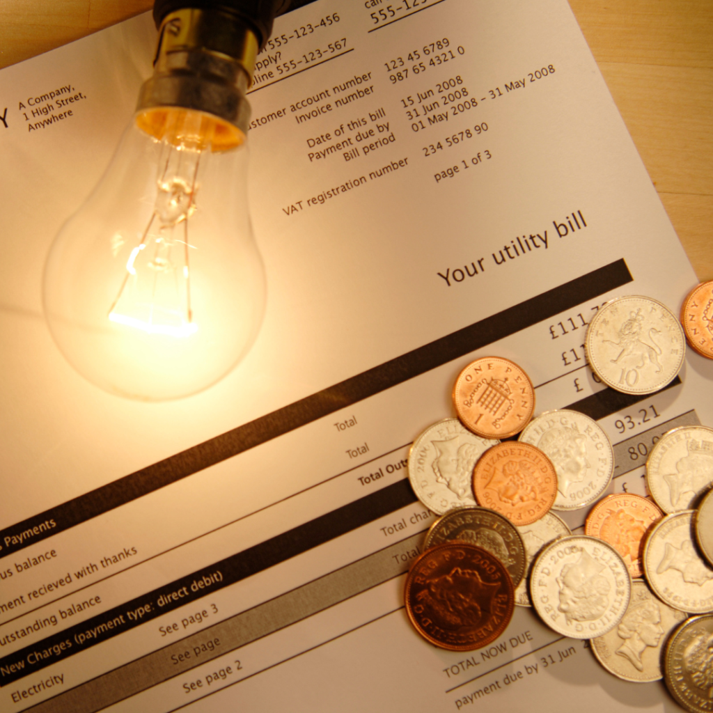 Utility bill with lightbulb and British coins for payment