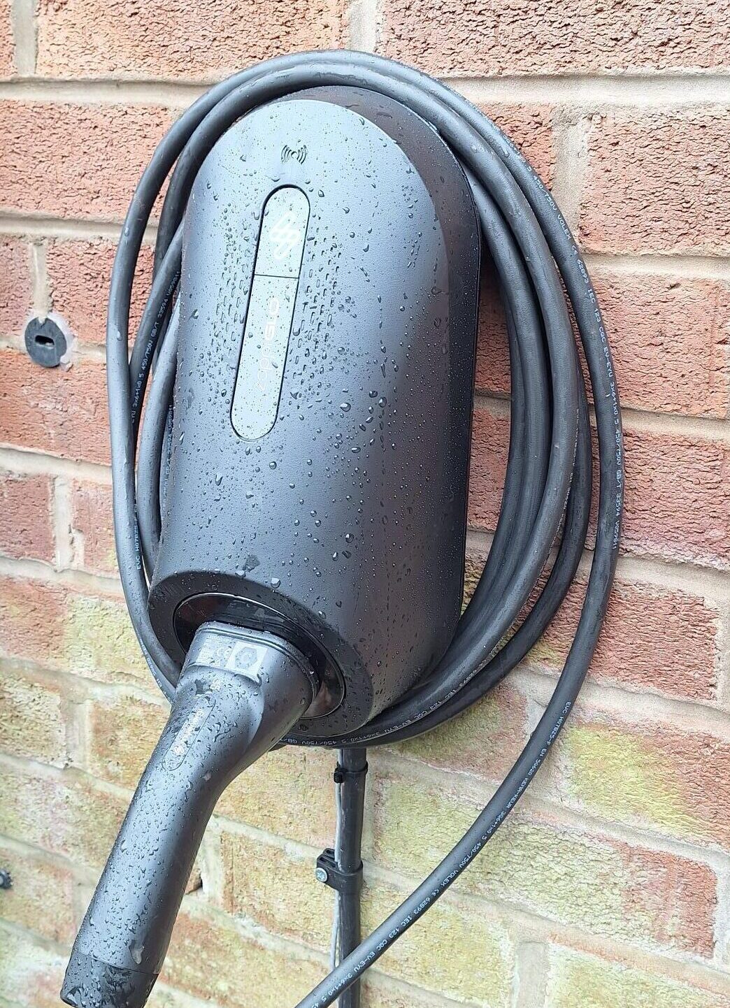 Electric vehicle charging point mounted on brick wall